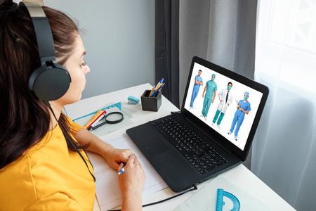 A girl makes a videoconference with general practitioners at home. The concept of online medicine, new technologies, modern possibilities of medicineの写真素材