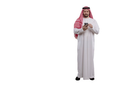 Male Arab with phone in hand isolated white background in traditional costume. Ready for cutting and editingの写真素材
