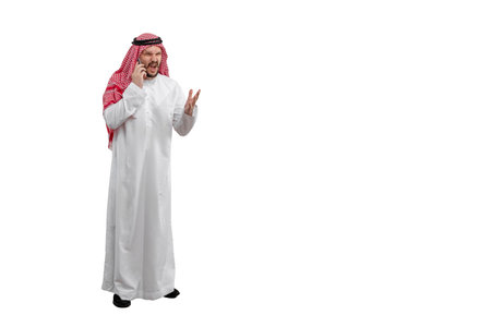 Arab man wearing on phone isolated white background in traditional costume. Ready for cutting and editingの写真素材