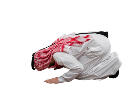 Arab man kneeling to pray , isolated white background in traditional costume. Ready for cutting and editingの写真素材