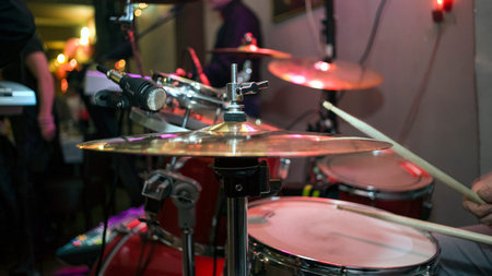 Hi hat cymbal and snare with drumsticks.