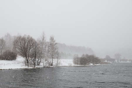 Pond in winter in with snow storm and trees.のeditorial素材