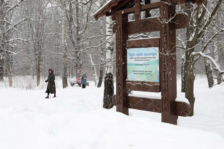 Moscow, Russia. 13th February 2021. A blizzard covered the city. A woman is walking on the snow with the sign of Terletskiy park.のeditorial素材