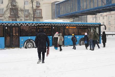 Moscow, Russia. 13th February 2021. A blizzard covered the city. People at the bus station under the snowのeditorial素材