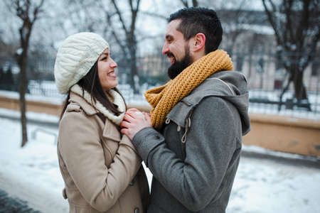 man hold girl on the street with snowの写真素材