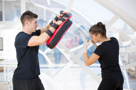 Young girl exercise punching with her coachの写真素材