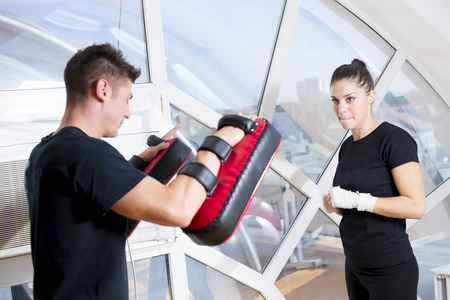Young girl exercise punching with her coachの写真素材