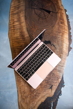 Pink laptop on a beautiful wooden tableの写真素材