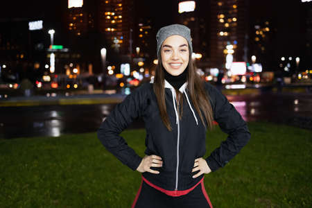 The smiling while prepares for a night run around the big cityの写真素材