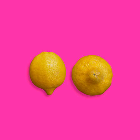 Yellow lemons on a pink background-breast cancer conceptの写真素材