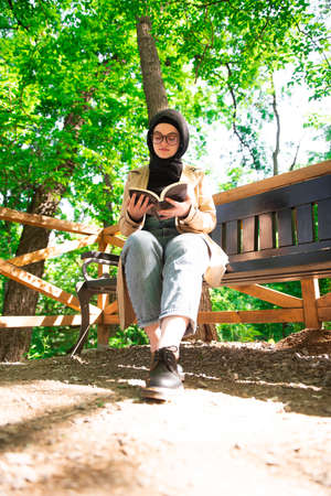 Beautiful Muslim woman researching a project in the parkの写真素材