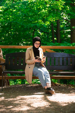 Beautiful Muslim woman researching a project in the parkの写真素材