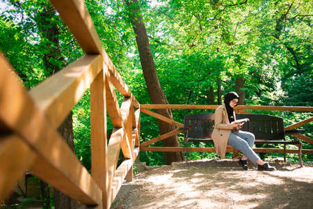 Beautiful Muslim woman researching a project in the parkの写真素材