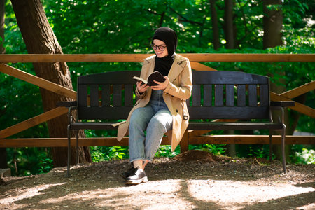 Beautiful Muslim woman researching a project in the parkの写真素材