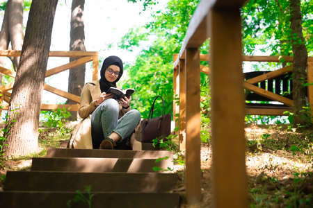 Beautiful Muslim woman researching a project in the parkの写真素材