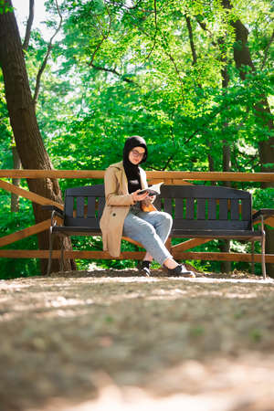 Beautiful Muslim woman researching a project in the parkの写真素材