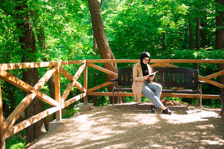 Beautiful Muslim woman researching a project in the parkの写真素材
