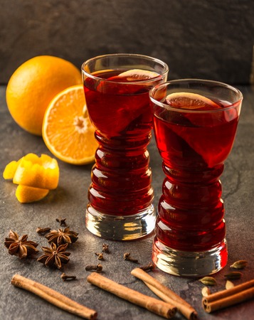 mulled wine with cinnamon sticks, oranges, star anise  on a dark tableの写真素材