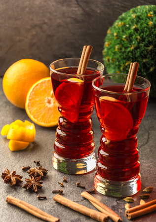 mulled wine with cinnamon sticks, oranges, star anise and  chrisymass balls on a dark tableの写真素材