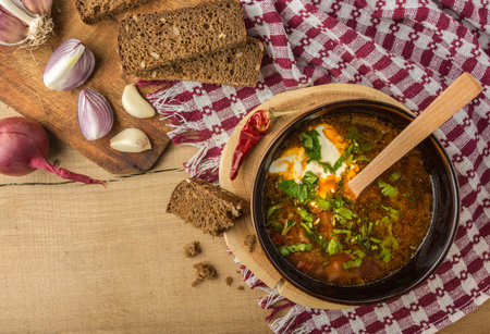 Tasty and nutritious borsch-soup with meat, potatoes, cabbage, tomatoes, beans, sour cream, parsley,...