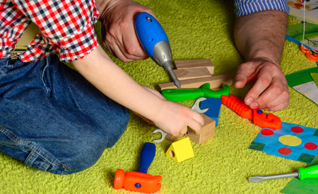 the father teaches the child to use the toolの写真素材