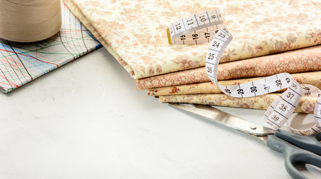 Accessories for sewing and cutting lie on a white table.  Space for an object.の写真素材