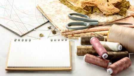 Accessories for sewing and cutting lie on a white table.  Space for an object.の写真素材