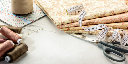 Accessories for sewing and cutting lie on a white table.  Space for an object.の写真素材