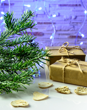Christmas festive card with fir branches, gift box and festive decor on the  background with Christmas lights.の写真素材