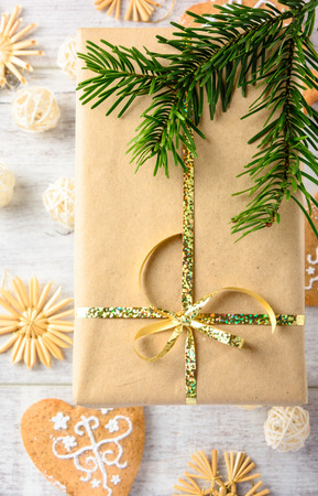 Christmas festive card with fir branches, gift boxes and cakes on the white wooden background . Flat lay.の写真素材