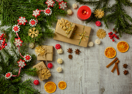 Christmas festive card with fir branches and festive decor on the white wood background. Flat lay.  Space for an object.の写真素材