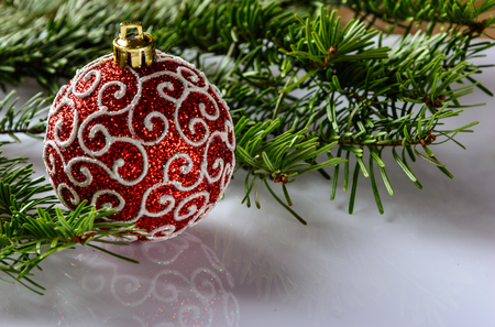 Christmas festive card with fir branches, Christmas ball and festive decor on the white background .  Space for an object.の写真素材