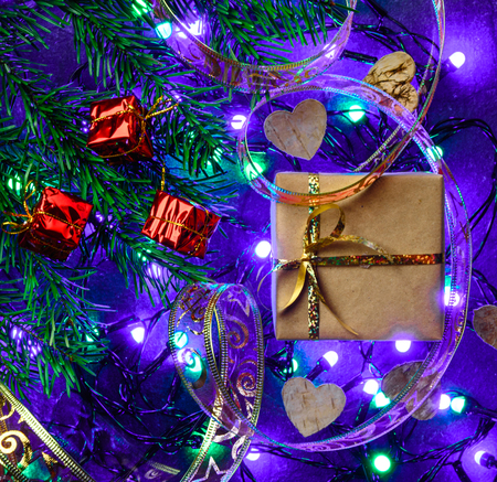 Christmas festive card with fir branches, gift box and festive decor on the clean background with Christmas lights. Flat lay.の写真素材