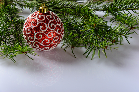 Christmas festive card with fir branches, Christmas ball and festive decor on the white background .  Space for an object.の写真素材