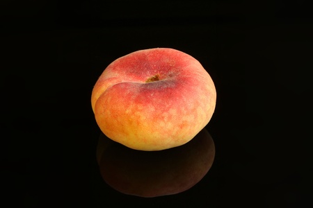 Close up shot of a peach isolated on a black backgroundの写真素材