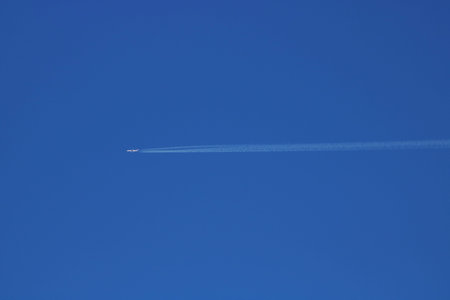 White trail from an airplane in a blue sky