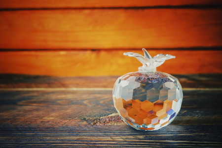 glass apple with edges on a wooden background, vintage styleの写真素材