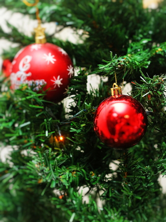 Closeup of red bauble hanging from a decorated Christmas tree. Vintage filter effectの写真素材