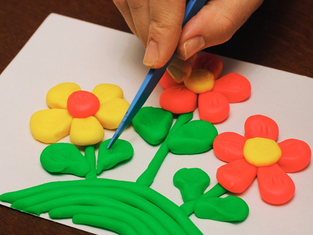 clay therapy. plasticine therapy. a boy sculpt clay figures. the teacher help him.の写真素材