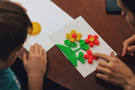 clay therapy. plasticine therapy. a boy sculpt clay figures. the teacher help him.の写真素材