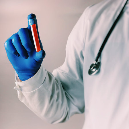 science, chemistry, biology, medicine and people concept - close up of male scientist or doctor holding test tube with blood sample making research in clinical laboratory.の写真素材
