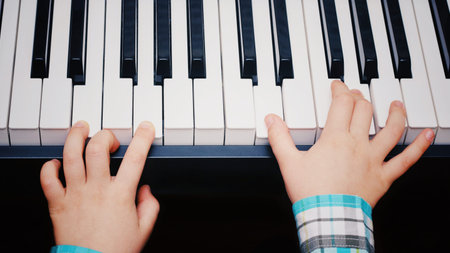 Piano Keys. Boy receives Piano Lessons. Hands of the boy on Piano Keys.の写真素材