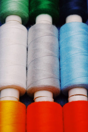 Background jeans fabric, thread, needles with threads, colorful background. Concept sewing business,...