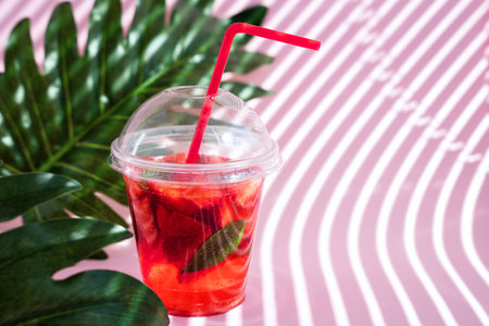 Refreshing summer lemonade with strawberries and fresh mint on pink background with shadows. close-up. copyspace. selective focus.の写真素材