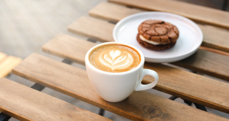 A cup of aromatic cappuccino and delicious chocolate cookies on a table in a street cafe. Coffee break on a summer sunny day. close-up. copyspace.の写真素材