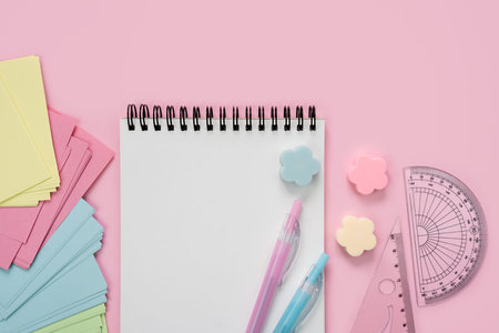 Blank notepad and school stationery on a pink background. back to school. flatlay. mockup. top view....