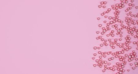 Minimalistic flatlay composition with pink decorative balls on a pink background. Holidays concept. Copy space. Top view.の写真素材