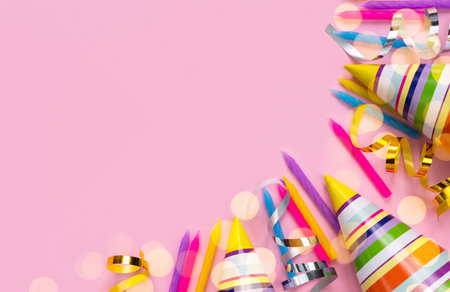 Bright colored party hats and holiday candles on a pink background. Holidays concept. Top view. Place for text.の写真素材