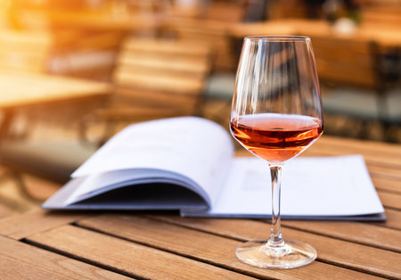 A glass with aperol on the table in a summer street cafe. Relaxation and enjoyment. Close-up. Place...