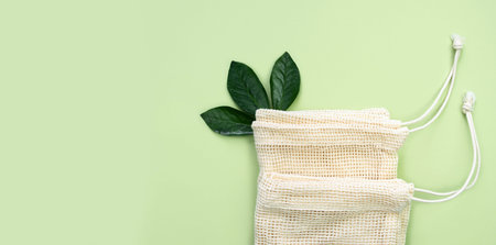 Reusable mesh bags made from eco friendly materials on the green background. Zero waste concept. Top...